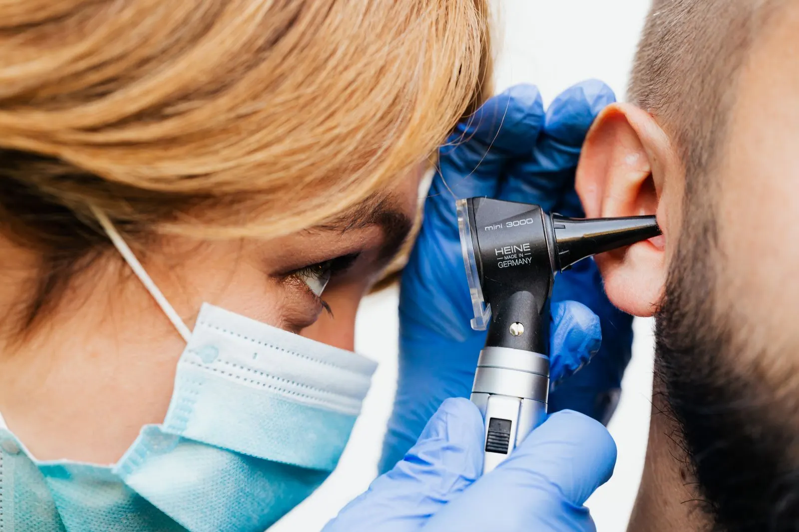 Médecin examinant l'oreille d'un patient à l'aide d'un otoscope en cabinet ORL
